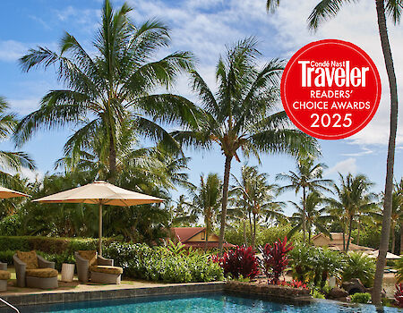 A tropical pool scene with lounge chairs, umbrellas, palm trees, and a red &ldquo;Travelers Choice Awards 2025&rdquo; badge.